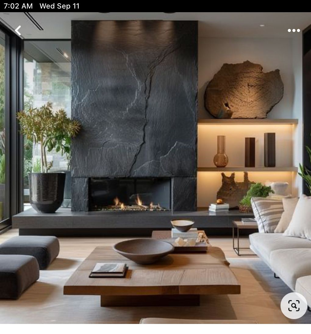 Nowoczesny salon z kominkiem jako głównym źródłem ogrzewania – elegancka aranżacja z kamienną zabudową i dużym przeszkleniem